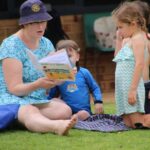Woman reading book to children